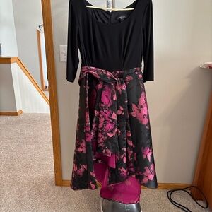 High/low black top with black and pink patterned skirt attached.